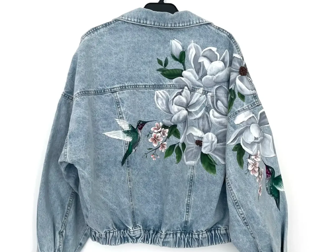 Campera de jean personalizada con magnolias y colibríes pintados a mano por Bel Dávalos
