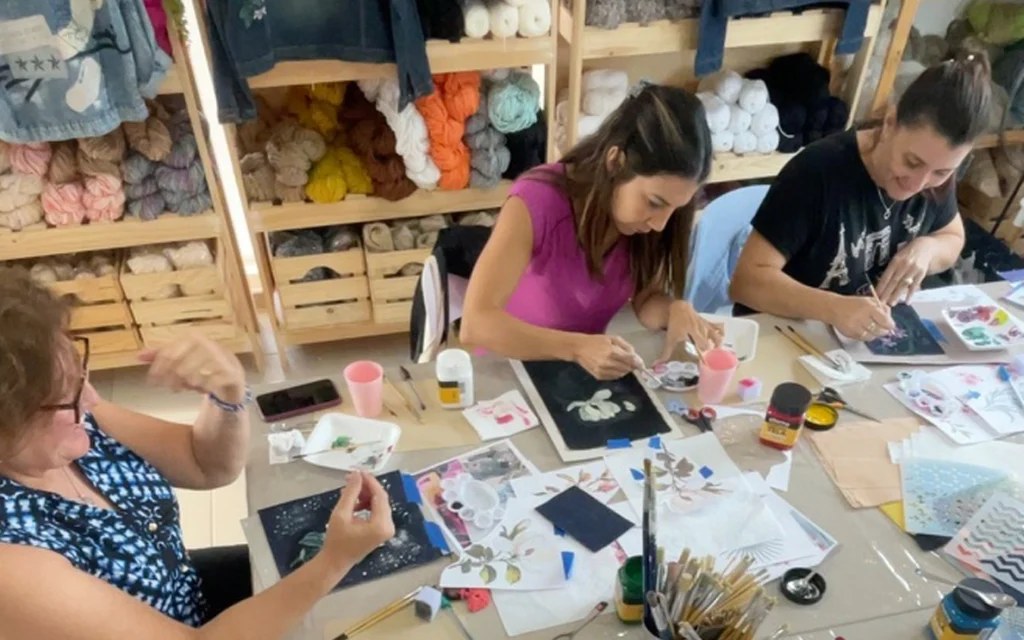 workshop de pintura sobre tela de jean con participantes pintando