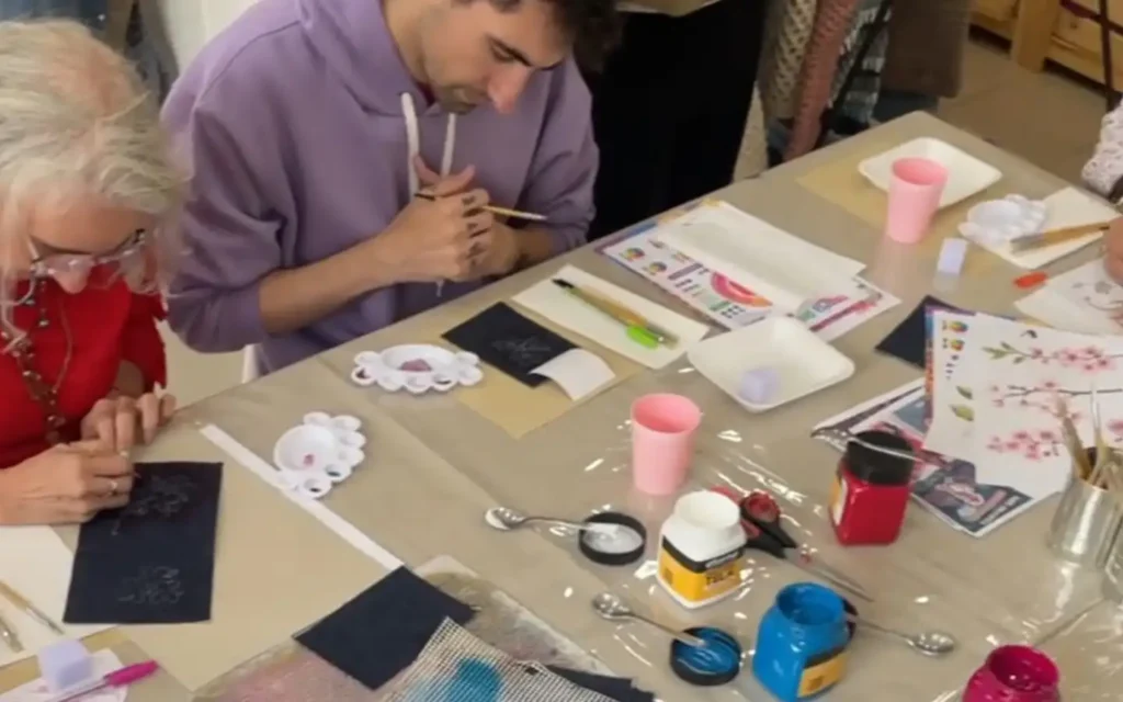 personas pintando prendas de jean durante workshop creativo